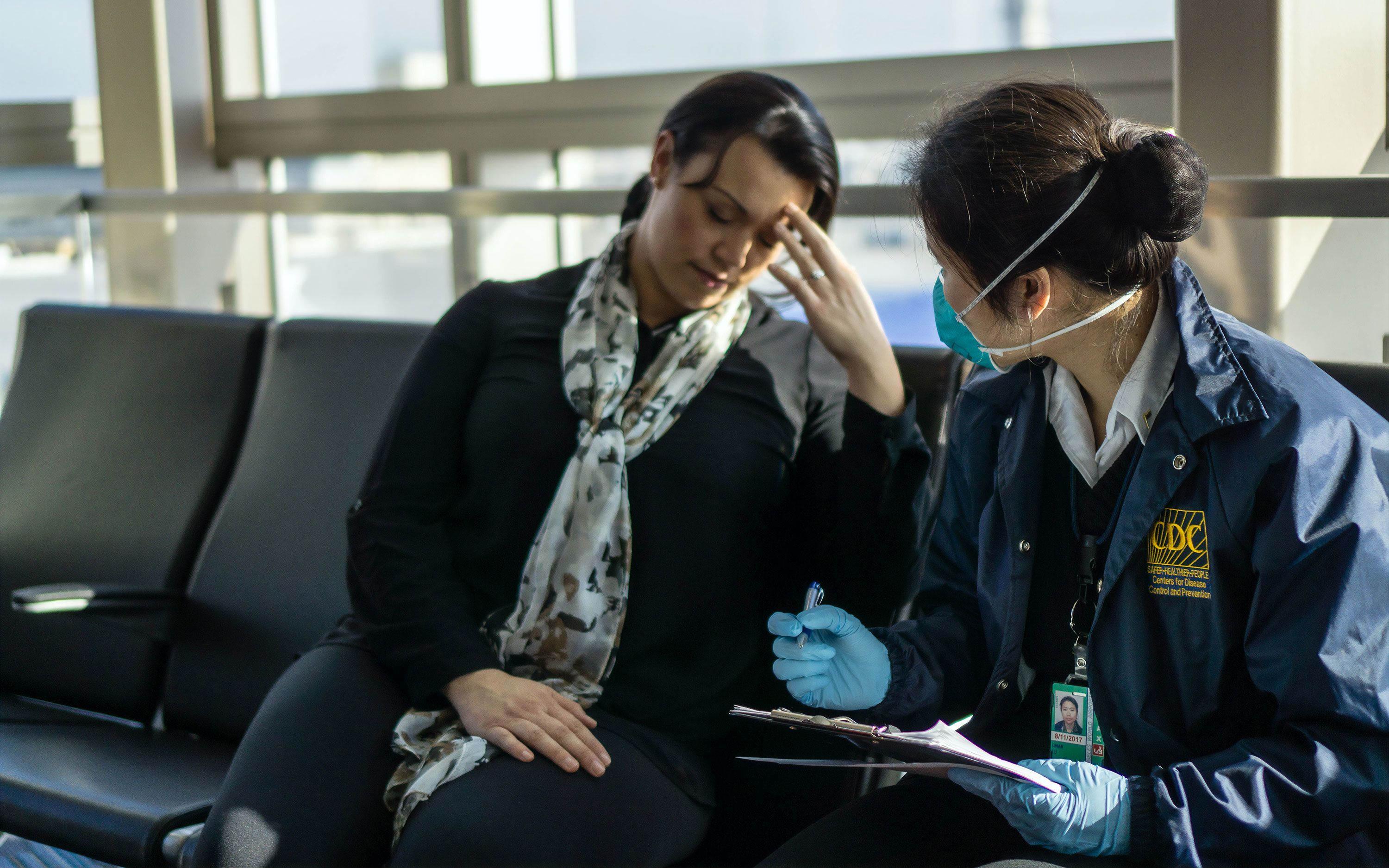 Woman speaking with CDC staff at airport