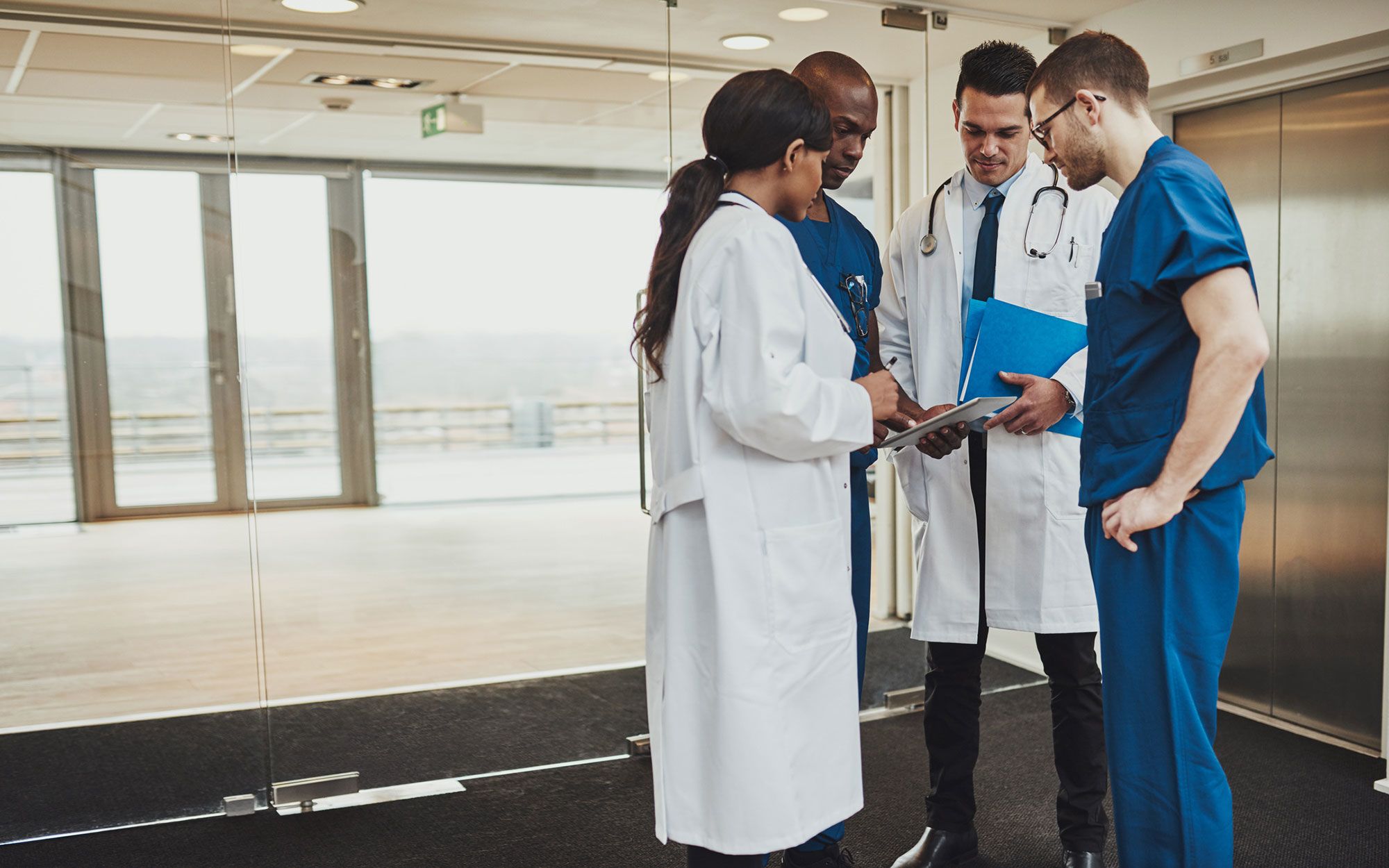 doctors sharing data on tablet in hospital