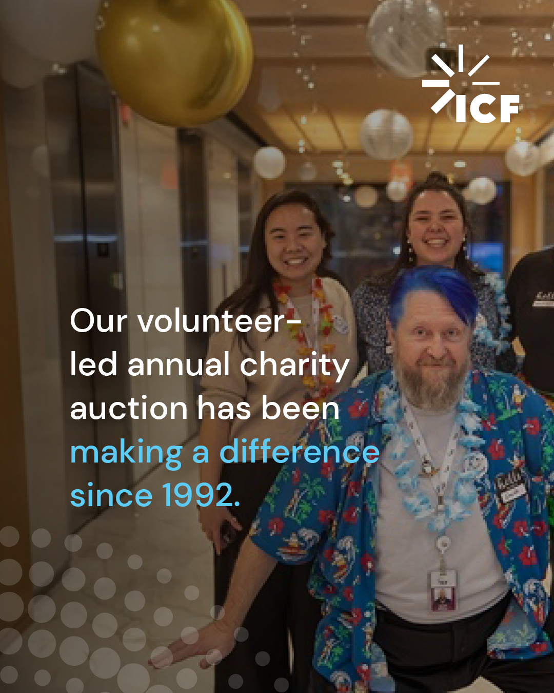 Volunteers with lei around their neck posing in hallway. Text overlay "Our volunteer-led charity auction has been making a difference since 1992.