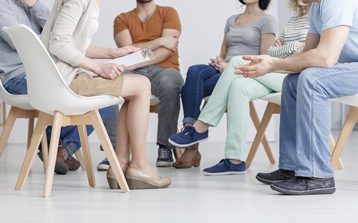 Support group talking in a circle, sitting on chairs