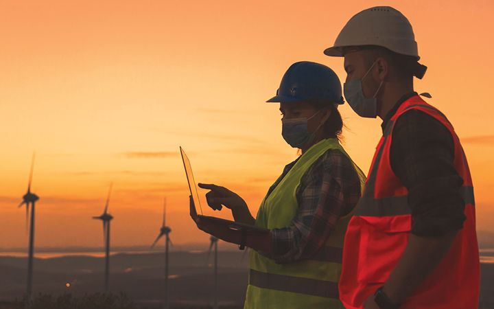 Engineers in front of wind farm