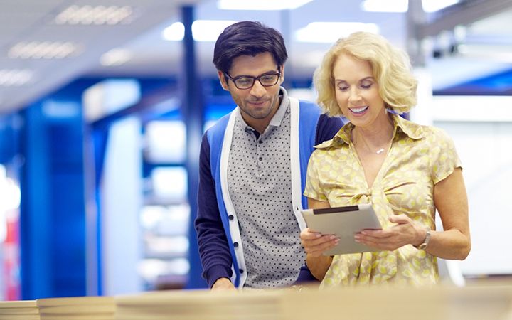 Woman shows something on a tablet to a man