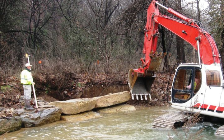 Machinery and person by water