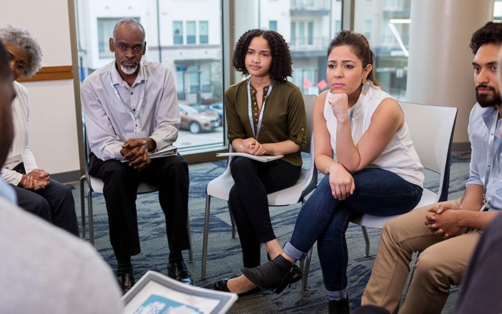People sitting and listening in community group.