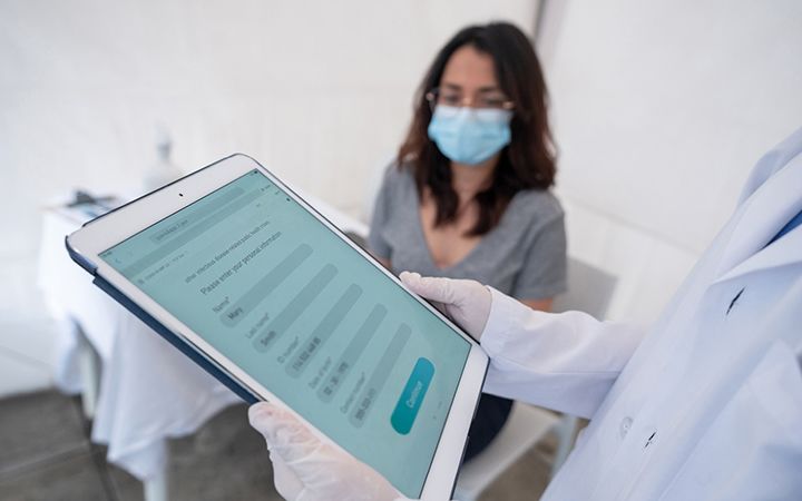 doctor using form on tablet with patient
