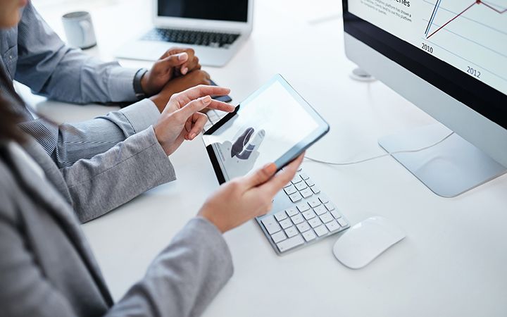 Two coworkers using a tablet