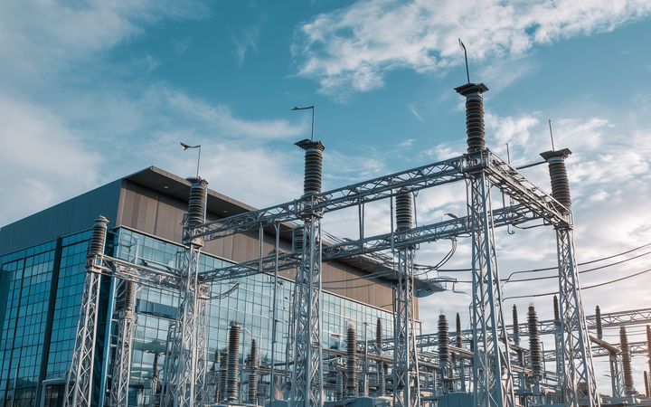 A landscape photo of a data center in front of a wispy clouded blue sky.