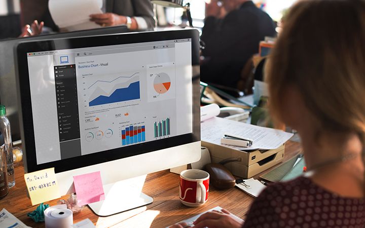 Woman looking at business chart on office monitor