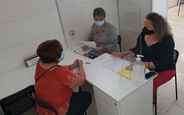 People meeting with a case manager from behind plexiglass divider