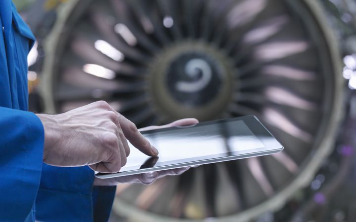 Man using touchscreen ipad, working on Airplane