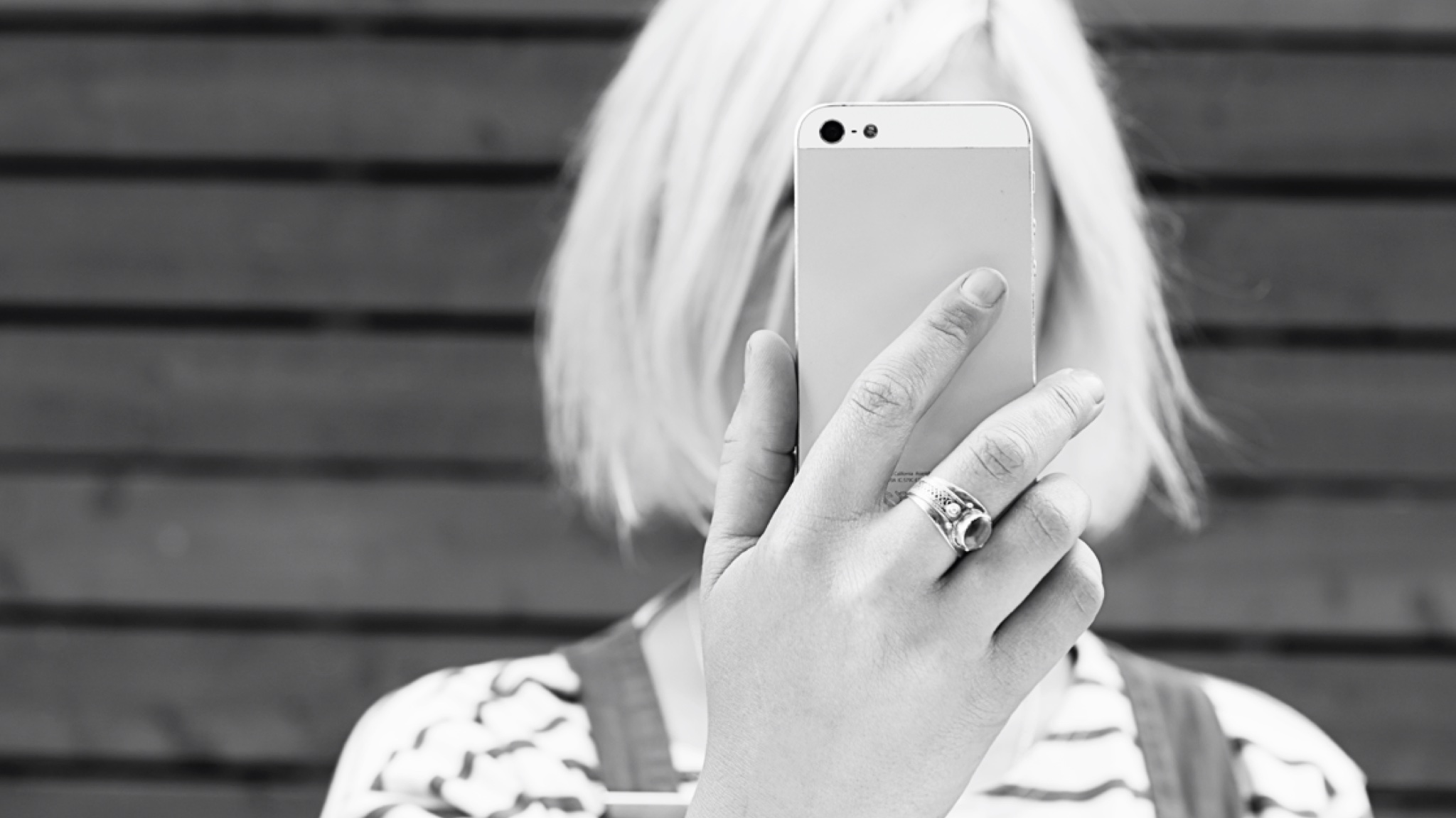 black and white image of female holding cell phone up