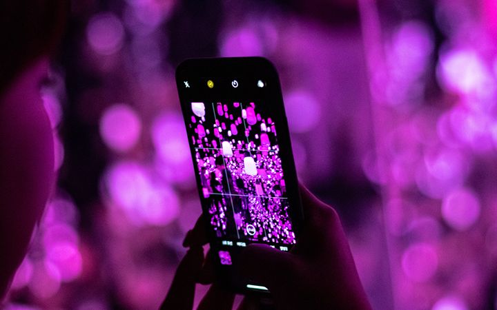Woman taking pictures of lights in her phone