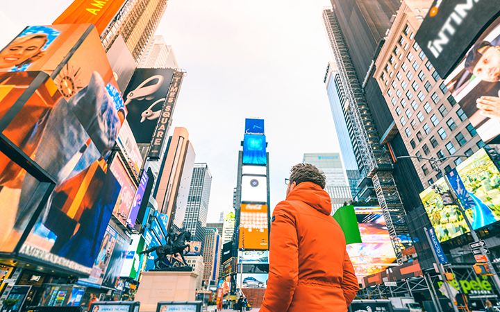 Man looking at large buildings in a city