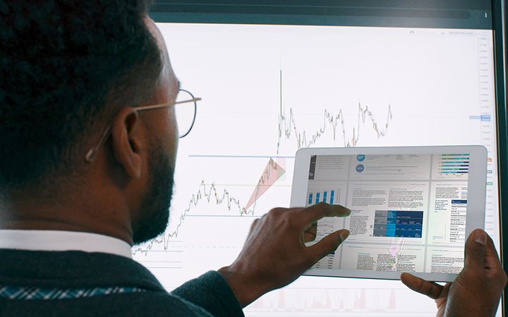 Man pointing at graph on tablet