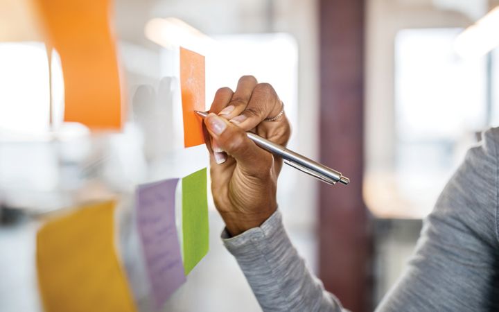 Woman writing on a sticky note